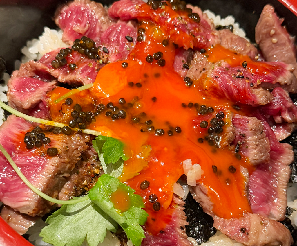 卵黄を崩して和牛とごはんに絡めたキャビア入りの漬け丼